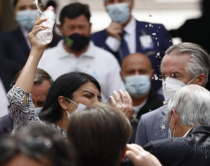 Una mujer lanza agua a Piñera durante un acto y su abuelo es quien se disculpa