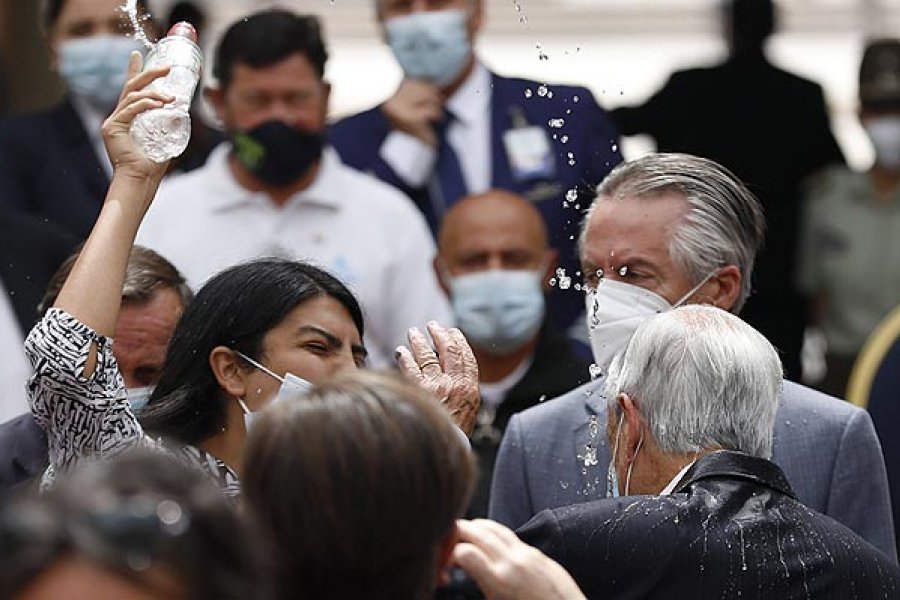 Una mujer lanza agua a Piñera durante un acto y su abuelo es quien se disculpa